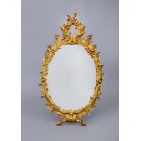A CARVED AND GILT WOOD PIER GLASS, 19th century, the oval plate with a border of flowering