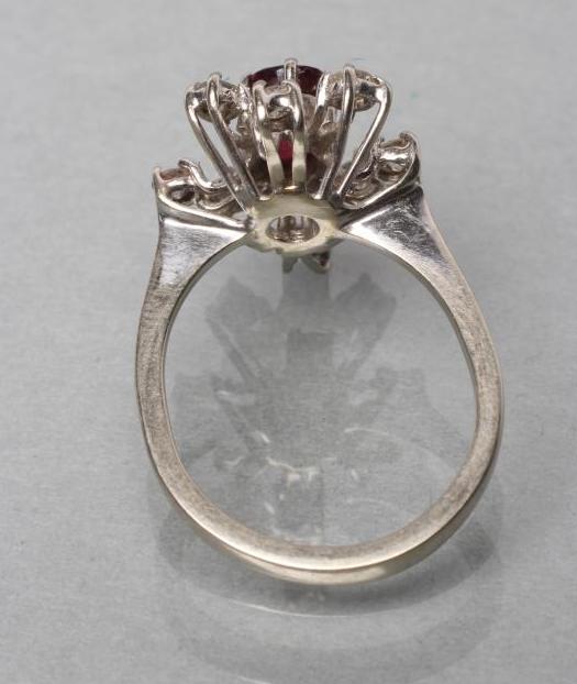 A RUBY AND DIAMOND DRESS RING, the oval facet cut ruby claw set to a star border of eight small - Image 2 of 2