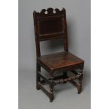 A JOINED OAK BACK STOOL, late 17th century, the panelled back with scrolled crest enclosed by square