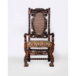 A CHARLES II CARVED WALNUT HIGH BACK ARMCHAIR, 17th century, the scroll carved back with oval