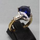 A SAPPHIRE DRESS RING, the pear cut stone claw set to shoulders each set with a shaped baguette