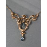 AN EDWARDIAN NECKLACE, the open seed pearl set cartouche pendant with two facet tear cut aquamarines
