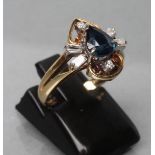 A SAPPHIRE AND DIAMOND DRESS RING, the tear cut sapphire claw set and flanked by two pairs of