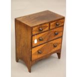 A VICTORIAN ROSEWOOD APPRENTICE CHEST of two short and three long drawers with turned wood