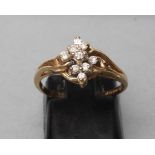 A DIAMOND CLUSTER RING, the nine small round brilliants claw set to twisted shoulders and a plain