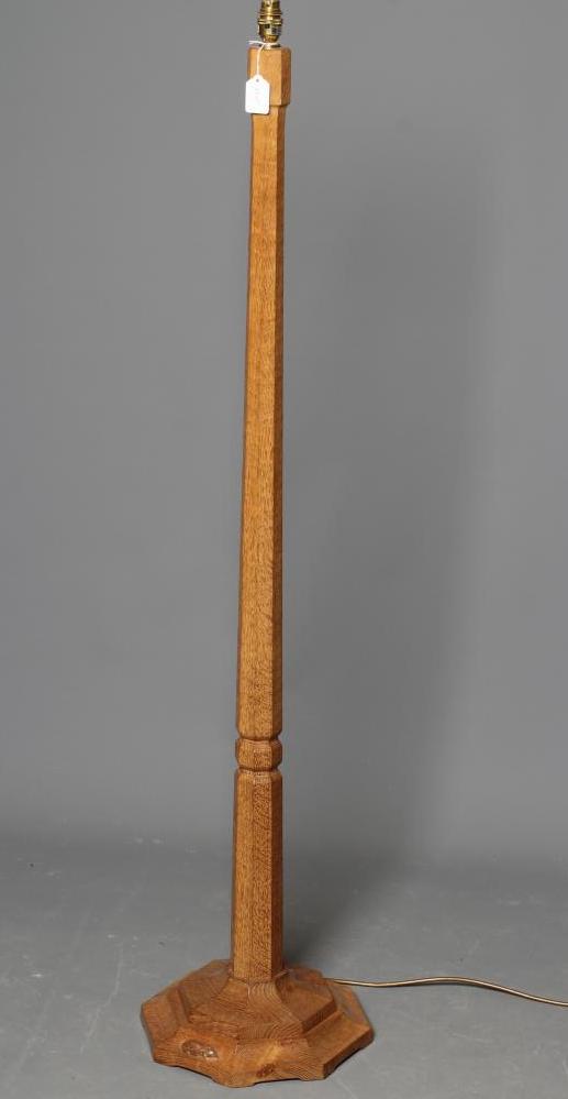 A ROBERT THOMPSON ADZED OAK STANDARD LAMP, of tapering faceted form with collared stem, the