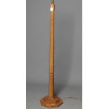 A ROBERT THOMPSON ADZED OAK STANDARD LAMP, of tapering faceted form with collared stem, the