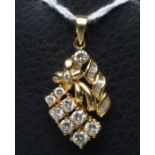 A DIAMOND PENDANT, the open leaf with a pair of four round brilliants, point set, and one panel