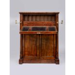 A REGENCY ROSEWOOD WRITING DESK of shallow oblong form, the panelled fallfront flanked by brass
