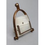 AN ART DECO WHITE ONYX PERPETUAL CALENDAR, the strut back supported on a spurred stirrup stand