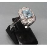 AN ART DECO DRESS RING, the square cut aquamarine claw set to baguette diamond set shoulders and ten