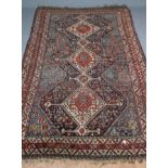 A SHIRVAN RUG, the pale blue and navy field with a column of six stepped ivory guls, with flowers,