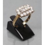 A DIAMOND DRESS RING, the four baguette cut central stones point set to a border of twelve brilliant