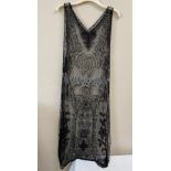 A 1920's beadwork dress, the net ground embellished with black and clear bugle beads. Approx 120