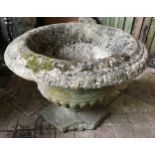 A reconstituted concrete garden urn on a circular pedestal on a square base approx. 64cms w x