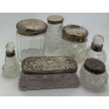 A collection of silver topped glass dressing table pots, scents and a hair tidy. (7).Condition