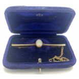Nine carat gold bar brooch set with Opal with safety chain, 6cm l. Total weight 4gm.Condition