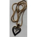 A 9 carat yellow and white gold heart set chain with diamond. 36cm l. 5.7gm.