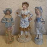 A pair of continental bisque figurines and a single figurine of a girl reading.Condition