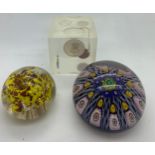 A millefiori paperweight together with another paperweight a/f and plastic cube containing coins.