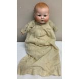 Bisque headed Armand Marseille doll with closing blue eye and open mouth with cloth body and plastic