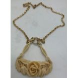 A 9 carat gold chain with carved ivory rose pendant. 14.3gm total weight.Condition ReportCrack to