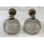 Two silver topped cut glass scent bottles with floral pattern to silver, Birmingham 1909 and
