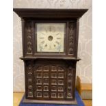 A carved oak wall clock with opening doors to base.Condition ReportBag with bits and pieces.