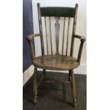 An early 20thC spell back armchair with upholstered panel to back.