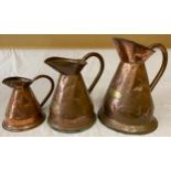 Three copper jugs with brass plates denoting size i.e. Quart, Half Gallon and One Gallon. Tallest