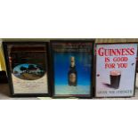 Two advertising Guinness signs, one metal, and a Southern Comfort advertising mirror.