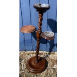 An oak barley twist smokers stand on brass paw feet with two associated glass ashtrays. 81cm h.