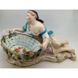 A John Bevington figural sweetmeat basket modelled as a classical lady seated by a shell shaped oval