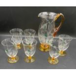 A water set comprising jug and 6 glasses with amber bases and amber handle, etched leaf pattern. Jug