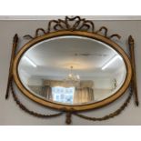 A gilt framed oval mirror with garland and bow decoration. 75 x 87cm.Condition ReportSlight losses