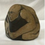 Painted stone of a naked man holding a dog with the signature Basicevsky 66 on the side stands 14cms