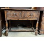 An oak side table with 2 drawers to front with carving. 114 w x 49 d x 84cm h.Condition