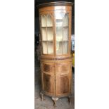 Walnut bow front corner cabinet, 2 glazed door top, 2 door base, claw and ball feet.Condition