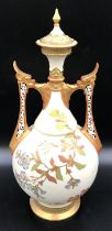 A Royal Worcester lidded vase with floral decoration and pierced dragon headed handles. 41cms.