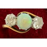 An 18ct gold ring set with central opal and diamonds to either side. Size R, 4.5gm.Condition