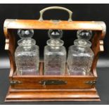 Oak cased, brass mounted three bottle tantalus with key, 36cm h to handle, base 39 w x 17cm d.