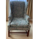 A wing backed upholstered armchair.Condition ReportMarks to front.