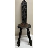 A heavily carved Anglo-Indian hardwood stool with ornately carved back and four snakes forming the