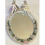 Continental porcelain framed mirror with putti and floral decoration 34cm x 26cm.Condition