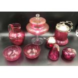 A selection of cranberry glass ware to include a tall lidded pedestal 27cms h, biscuit barrel with