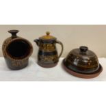 Three pieces of slipware pottery to include salt pig, coffee/ teapot and lidded dish. Salt pig