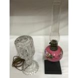 Two table lamps, one heavy cut glass in two sections 36cms h. Pink glass oil lamp with floral