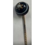Banded agate and seed pearl mourning stick pin set on yellow metal.