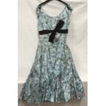 A 1950's ladies dress, handmade, light ble with black bow and fitted underskirt approx. size 26 inch