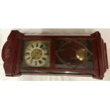 Mahogany wall mounted clock with roman numerals on clock face. Believed to be working order, winds